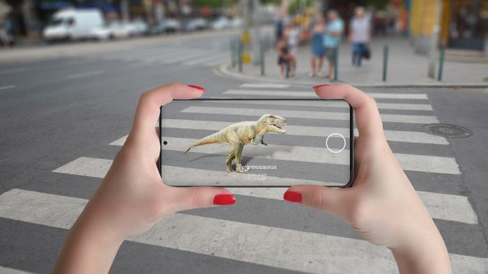 Projection of a Tyrannosaurus on a crosswalk, which can be seen in the smartphone.