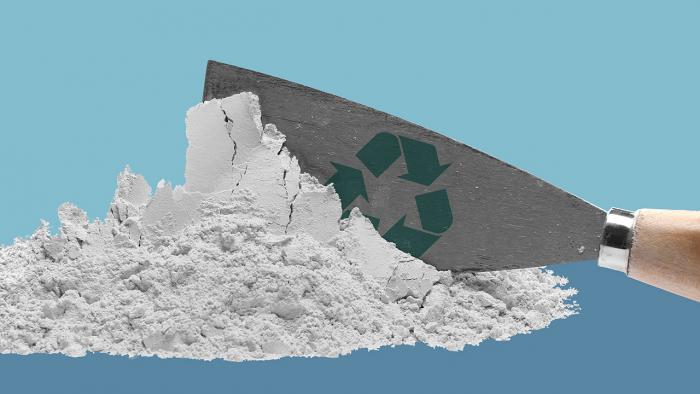 Spachtel mit Recycling-Logo in Gips-Häufchen