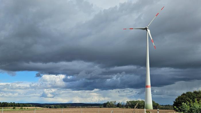 Wind turbine in front of a dramatically cloudy sky