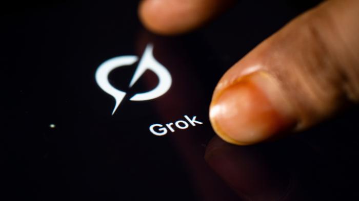 Two fingers tapping on a smartphone on the Grok app