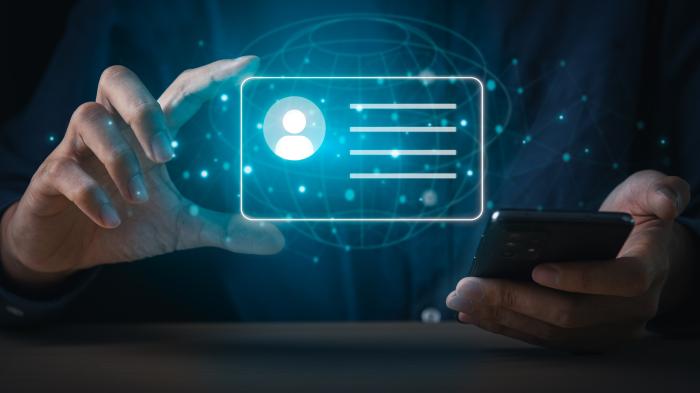 Projection of a digital identity onto a card held by a hand. In the person's other hand, there is presumably a smartphone.