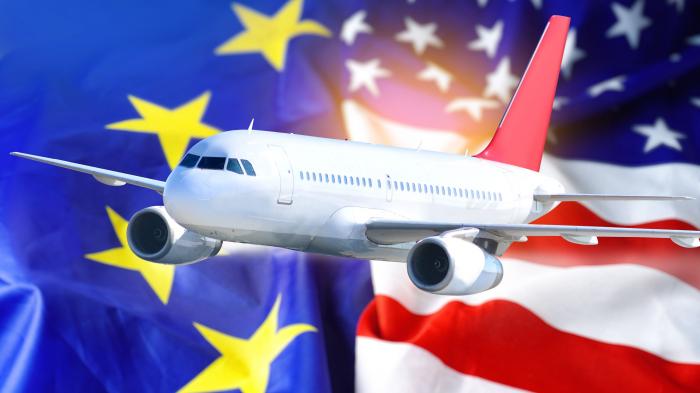 Flugzeug über den Flaggen der EU und den USA