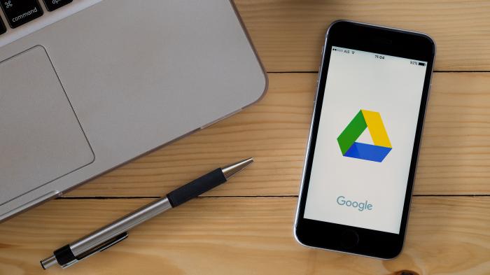 Google Drive auf einem Smartphone, links daneben ein Laptop und ein Stift
