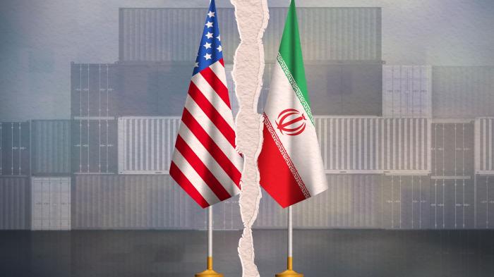 Zwei Fahnen, USA und Iran, sind durch einen Riss getrennt. Im Hintergrund Container.
