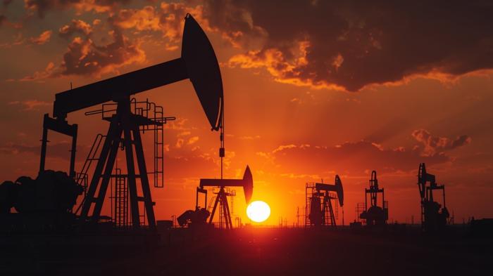 Silhouetten von Ölförderpumpen bei Sonnenuntergang