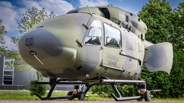 Ein Airbus U145 Hubschrauber mit Tarnmuster auf einem Fahrgestell.