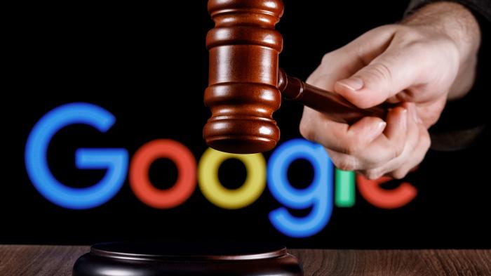 Hand mit Holzhammer vor Google-Logo