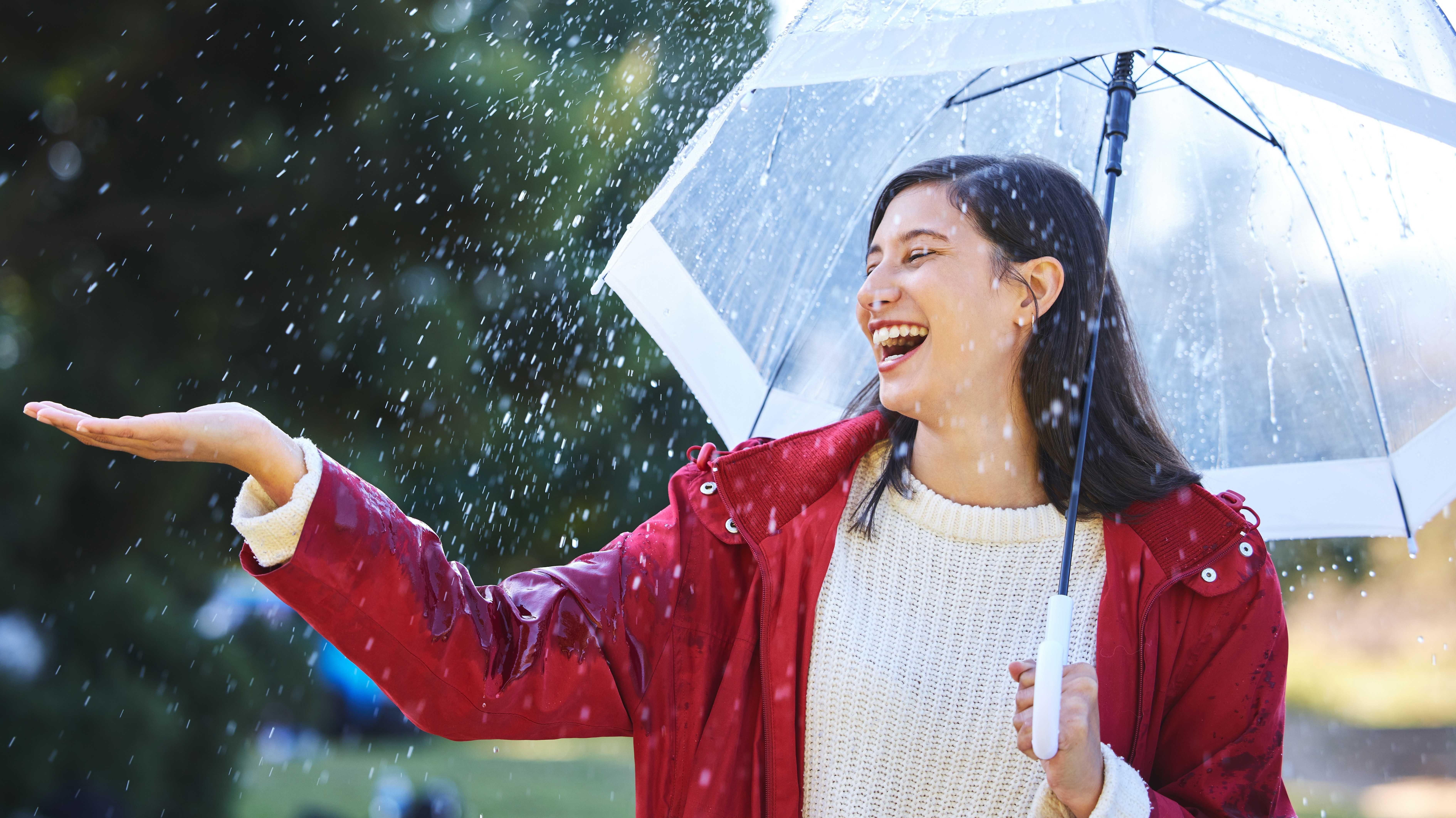 Frau mit Regenschirm im Regen