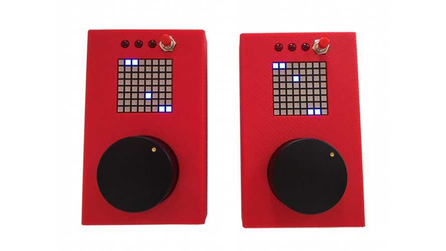 Zwei rote Handheldgeräte mit pixeligem Display und schwarzem runden Button